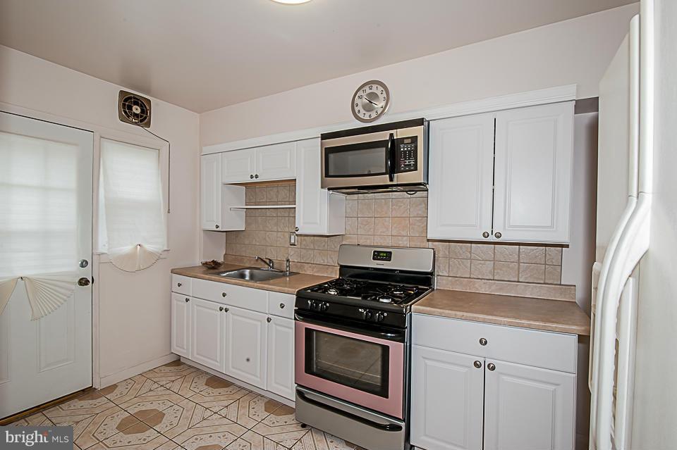 1072 Craftswood Road Baltimore, MD 21228 - Photo 2 of 18 a kitchen with stainless steel appliances a stove a microwave and cabinets