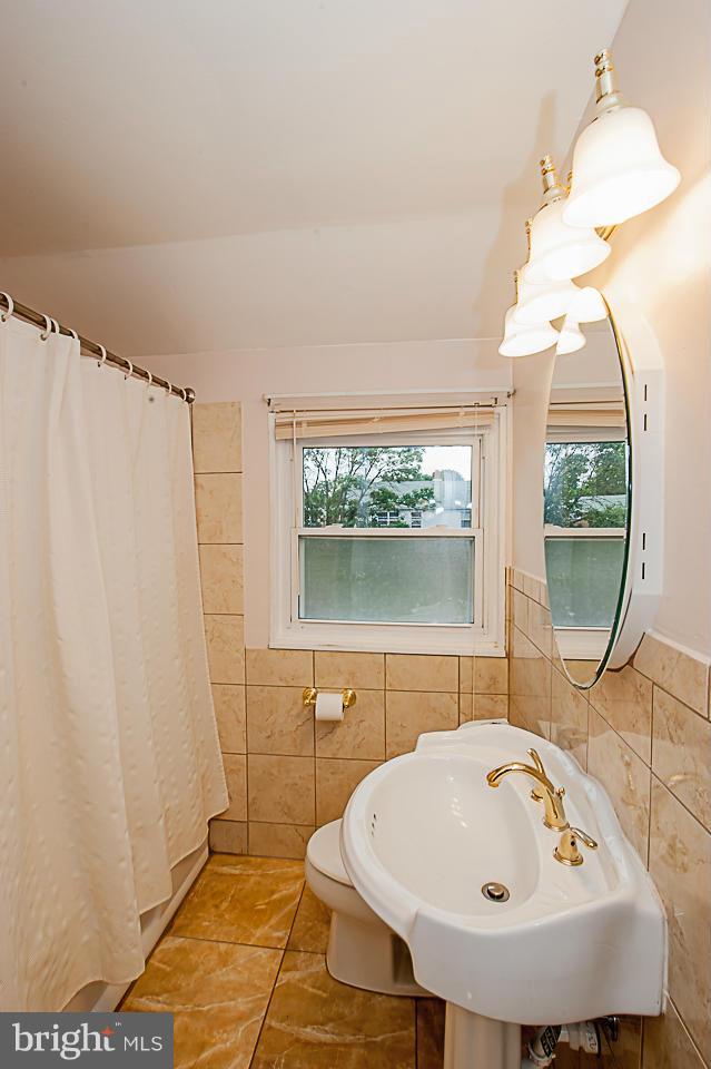 1072 Craftswood Road Baltimore, MD 21228 - Photo 12 of 18 a bathroom with a sink a window and a mirror