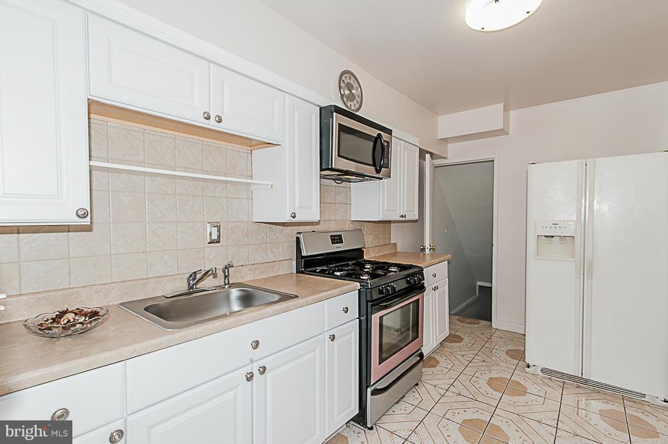 1072 Craftswood Road Baltimore, MD 21228 - Photo 6 of 18 a kitchen with stainless steel appliances a sink stove and refrigerator