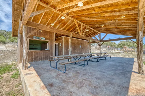 a view of a patio with table and chairs with wooden floor and fence