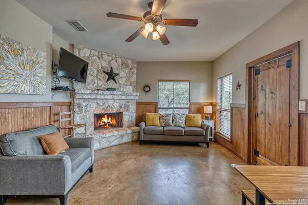 a living room with furniture a flat screen tv and a fireplace