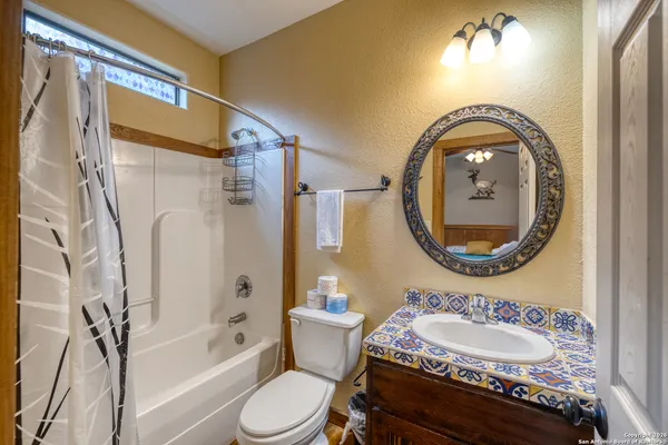 a bathroom with a granite countertop toilet a sink and a bathtub