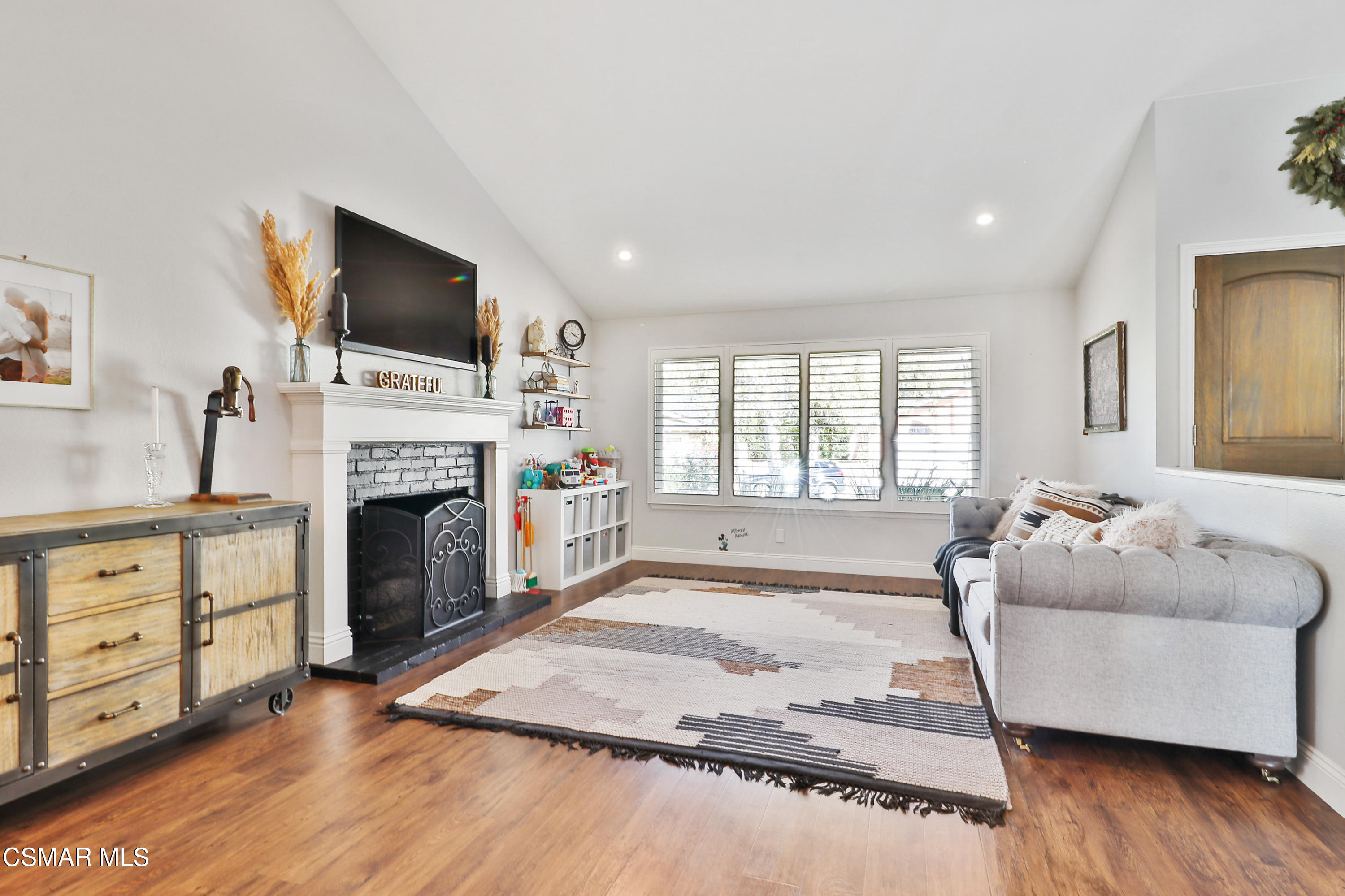 5938 Serena Street Simi Valley, CA 93063 - Photo 14 of 76 a living room with furniture a flat screen tv and a fireplace