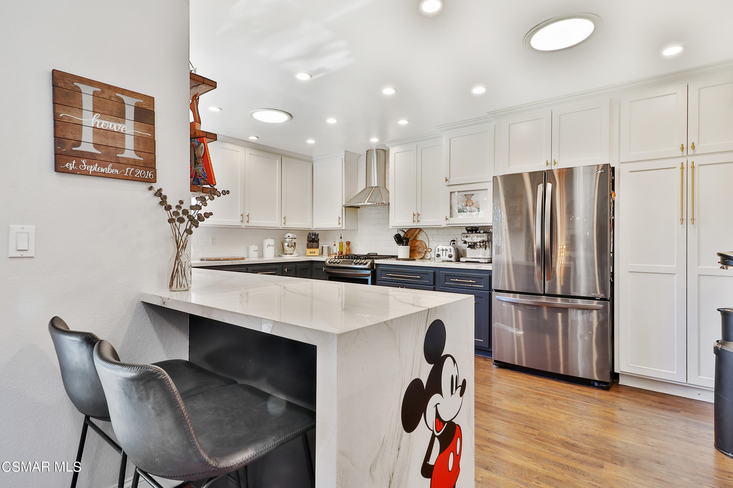 5938 Serena Street Simi Valley, CA 93063 - Photo 42 of 76 a kitchen with kitchen island a refrigerator stove and microwave