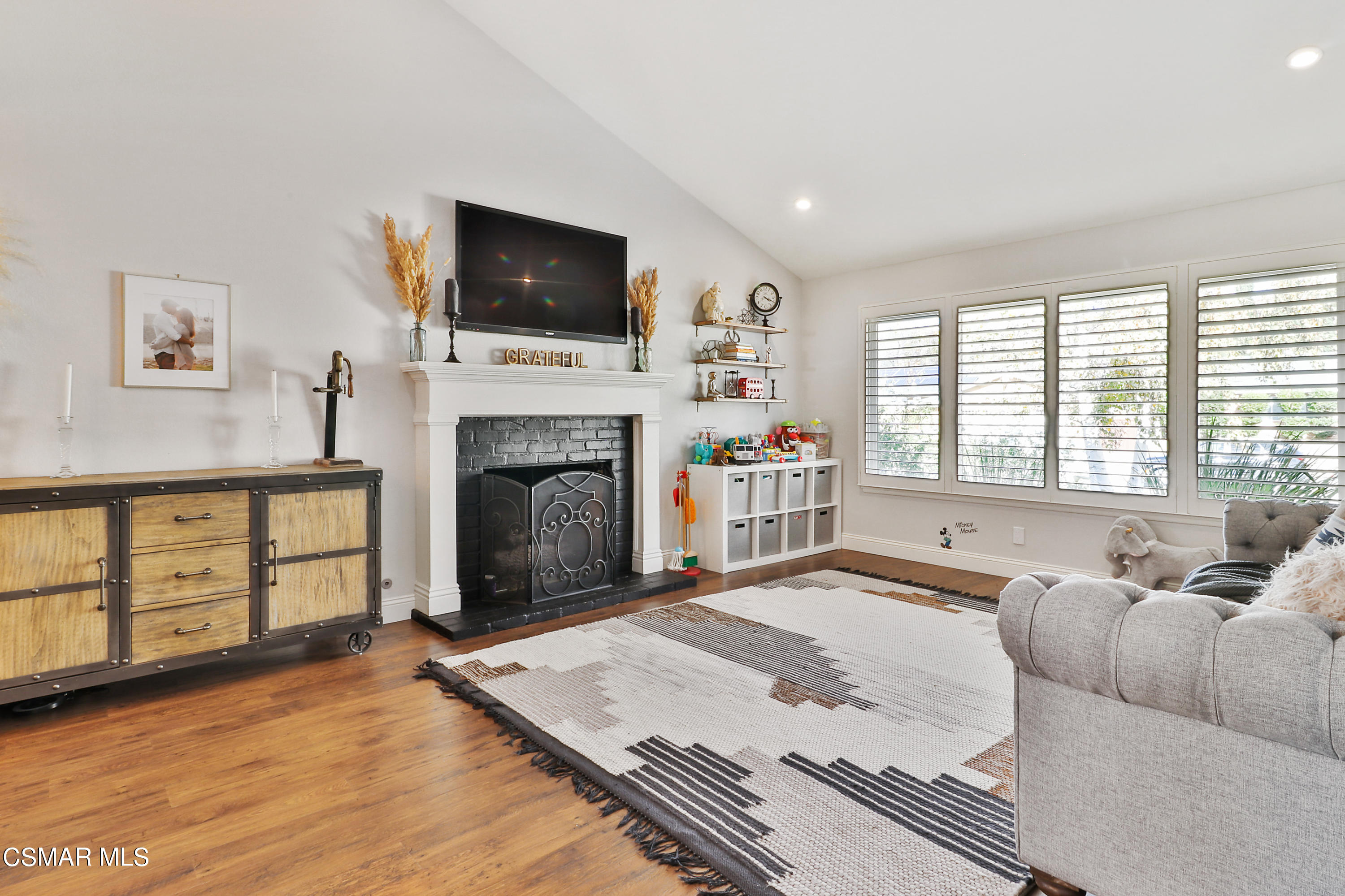 5938 Serena Street Simi Valley, CA 93063 - Photo 10 of 76 a living room with furniture a flat screen tv and a fireplace