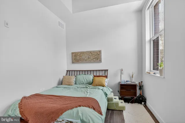 a view of a bedroom with wooden floor and a ceiling fan