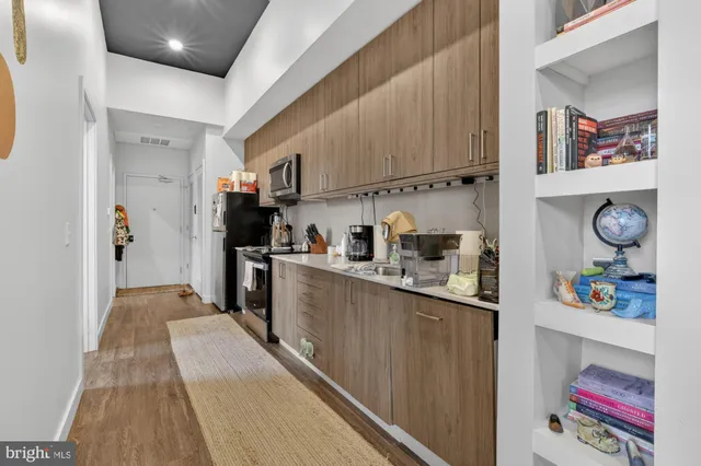 a kitchen with stainless steel appliances granite countertop a refrigerator and a stove top oven