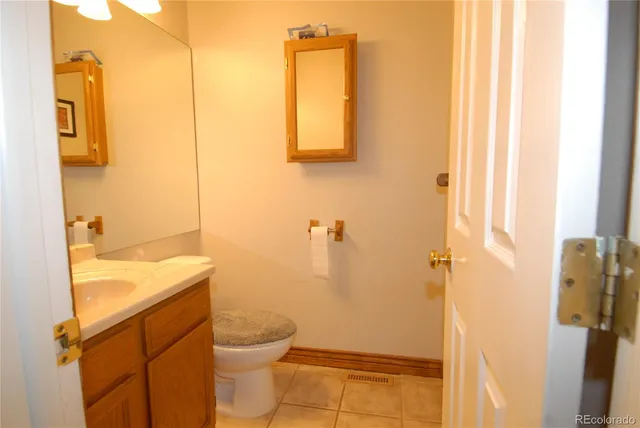 a bathroom with a granite countertop toilet sink and mirror