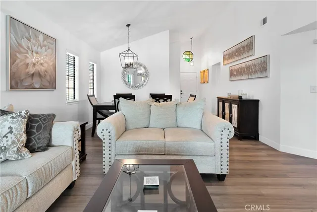 a living room with furniture a dining table and paintings on the wall