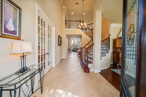 a dining room with wooden floor a chandelier a wooden table and chairs