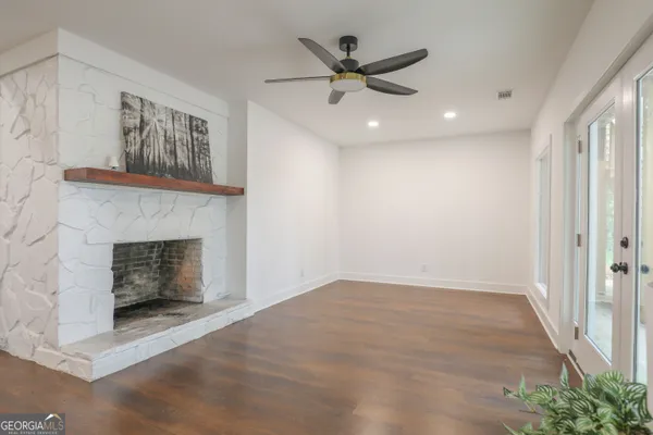 a dining room with furniture large windows and wooden floor