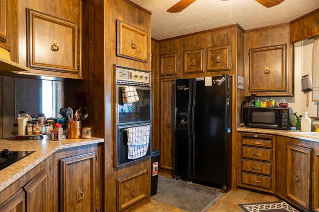 a kitchen with stainless steel appliances granite countertop a refrigerator and a stove