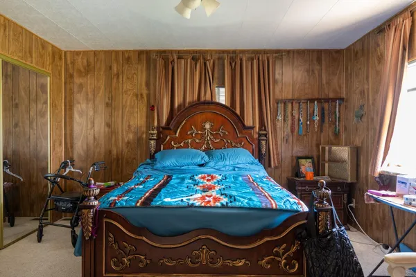 a bedroom with a bed a dresser and a window