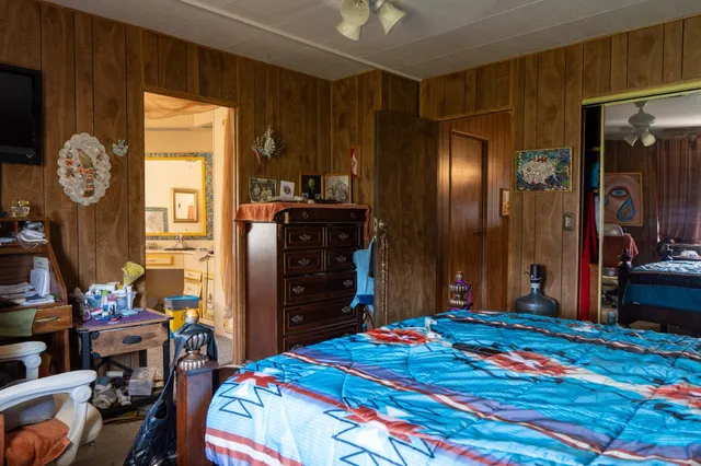 a bedroom with a bed table and chair