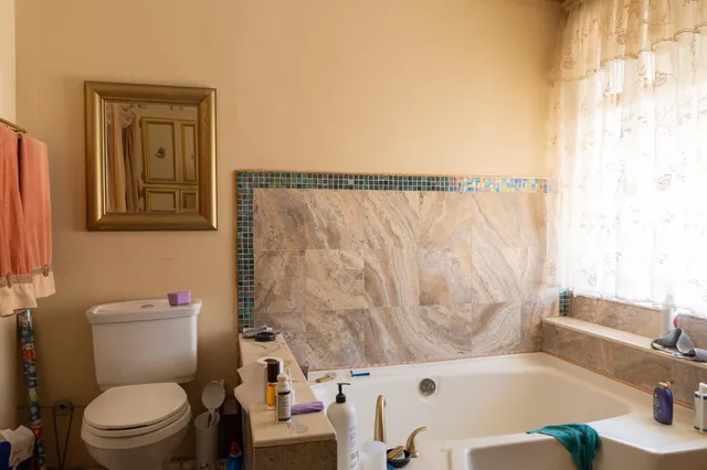 a white toilet sitting next to a bath tub