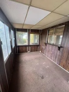 a view of an empty room with a fireplace and a window