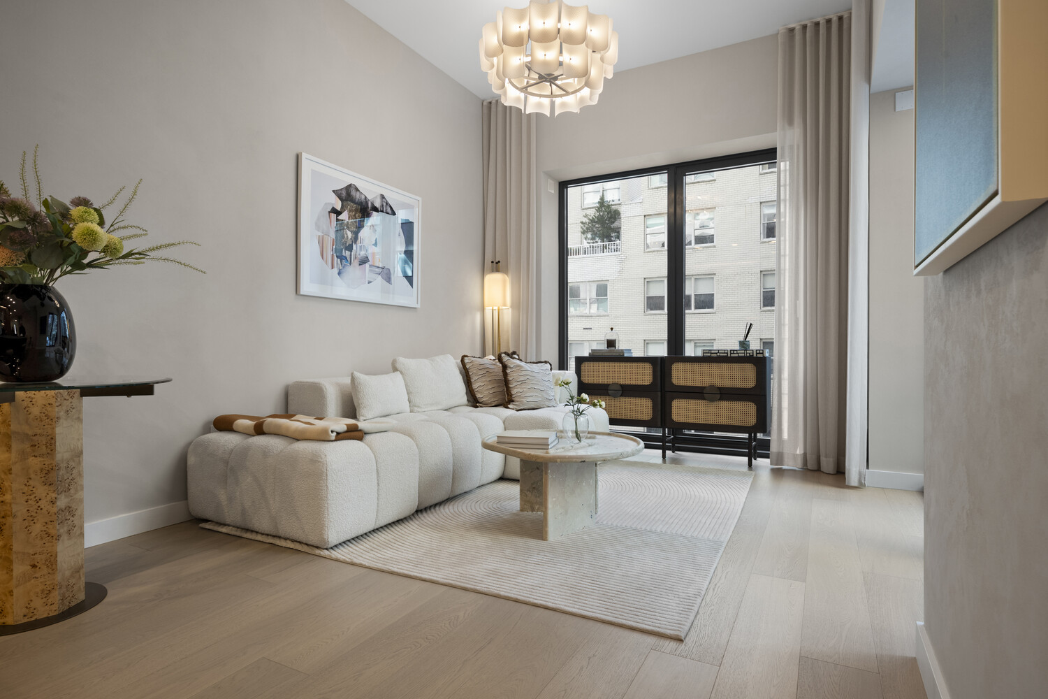 126 East 57th Street, Unit 2401 Manhattan, NY 10022 - Photo 1 of 26 a living room with furniture a table and a large window