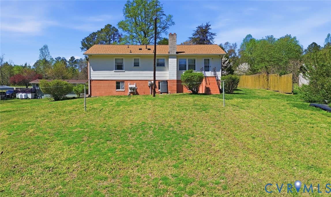 19353 Boulwares Road Ruther Glen, VA 22546 - Photo 40 of 62 Rear view of house featuring a chimney and a balco