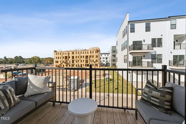 a balcony with wooden floor table and chairs