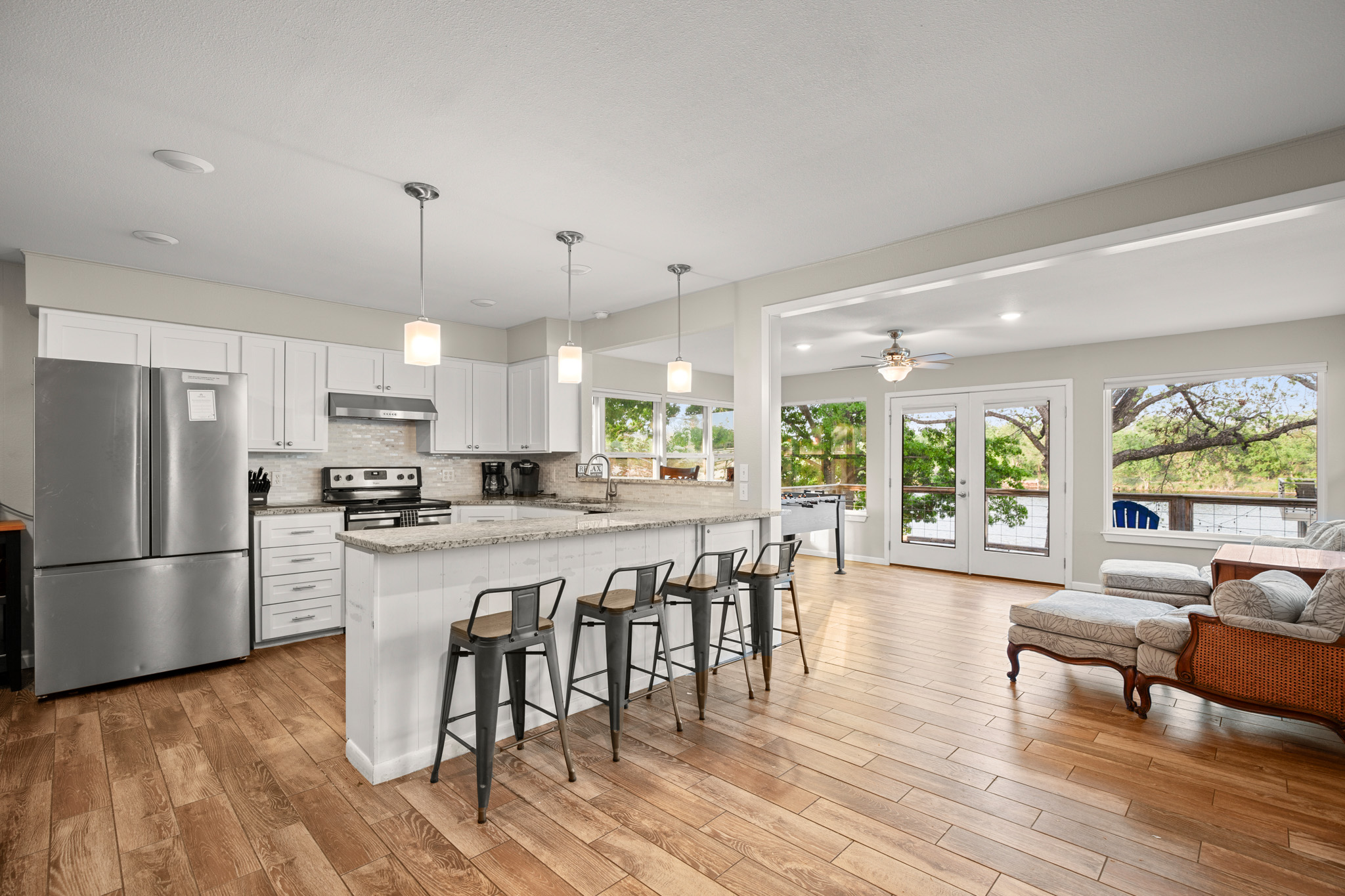 508 Riverside Drive Kingsland, TX 78639 - Photo 13 of 39 a kitchen with stainless steel appliances granite countertop a stove a refrigerator a kitchen island a dining table and chairs with wooden floor