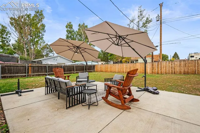 a view of backyard with outdoor seating and wooden fence