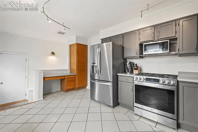a kitchen with stainless steel appliances granite countertop a stove a microwave and a refrigerator