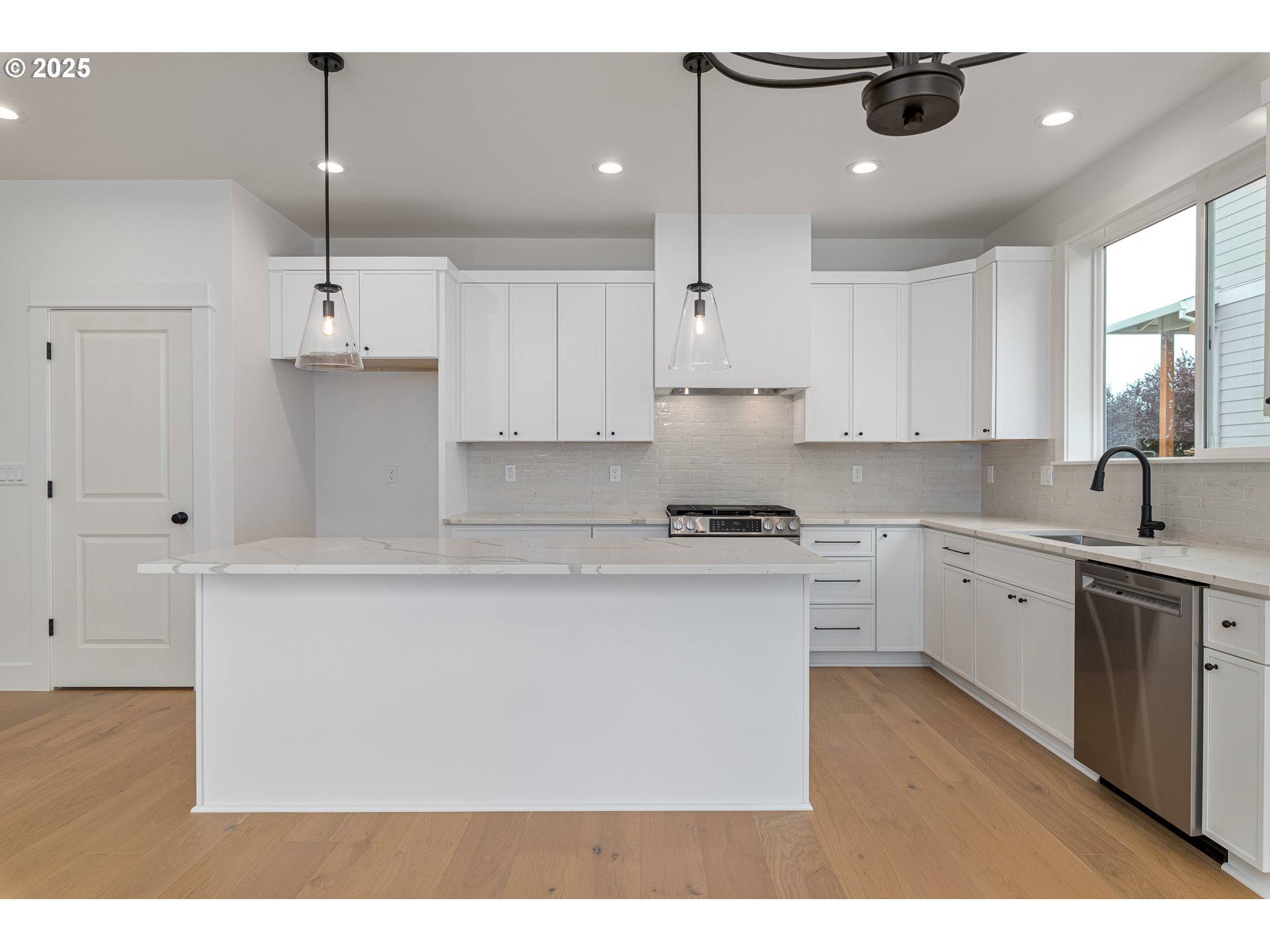 2263 Southwest Phyllis Place Gresham, OR 97080 - Photo 8 of 34 a kitchen with kitchen island white cabinets and white appliances