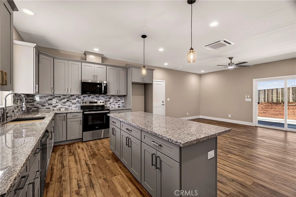 5617 Scottwood Road Paradise, CA 95969 - Photo 11 of 55 a kitchen with a stove a sink dishwasher a refrigerator and white cabinets with wooden floor