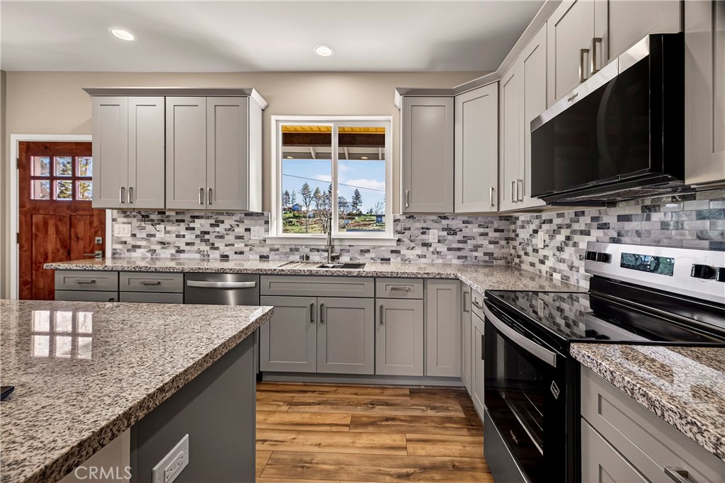 5617 Scottwood Road Paradise, CA 95969 - Photo 14 of 55 a kitchen with stainless steel appliances granite countertop a sink stove and microwave