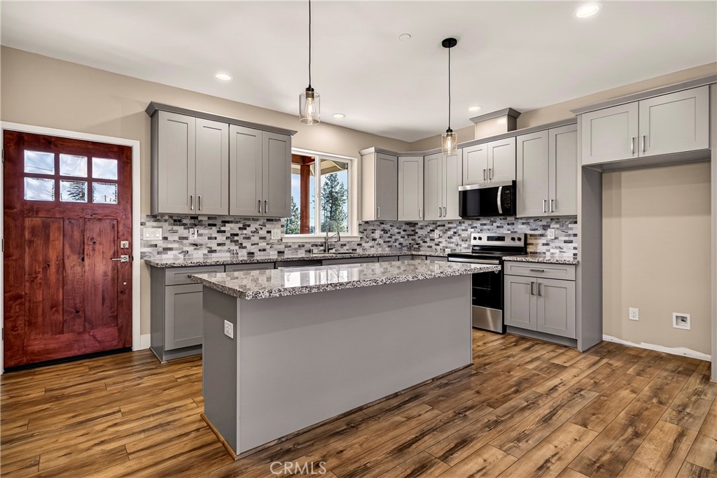 5617 Scottwood Road Paradise, CA 95969 - Photo 10 of 55 a kitchen with stainless steel appliances kitchen island granite countertop a sink stove and refrigerator