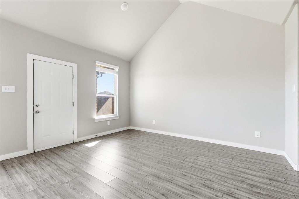 348 Braves Way Lavon, TX 75166 - Photo 12 of 26 a view of an empty room with wooden floor and a window