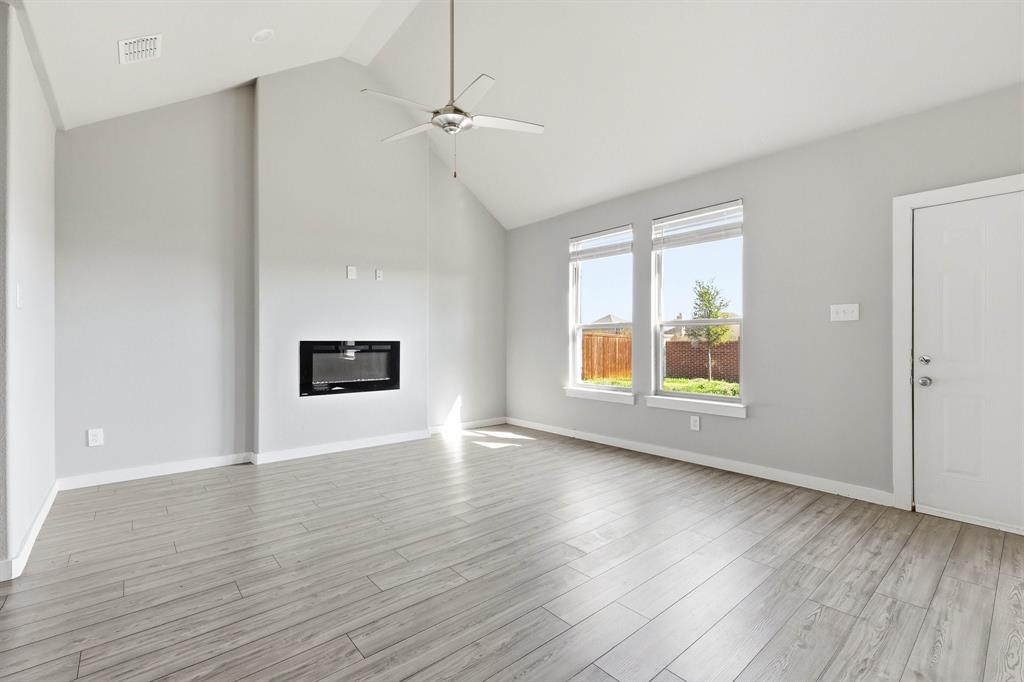 348 Braves Way Lavon, TX 75166 - Photo 2 of 26 an empty room with wooden floor and windows