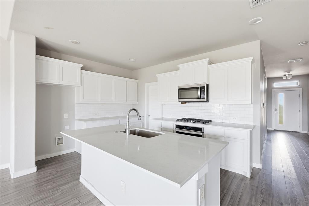 348 Braves Way Lavon, TX 75166 - Photo 4 of 26 a kitchen with a sink dishwasher a stove and a refrigerator with wooden floor