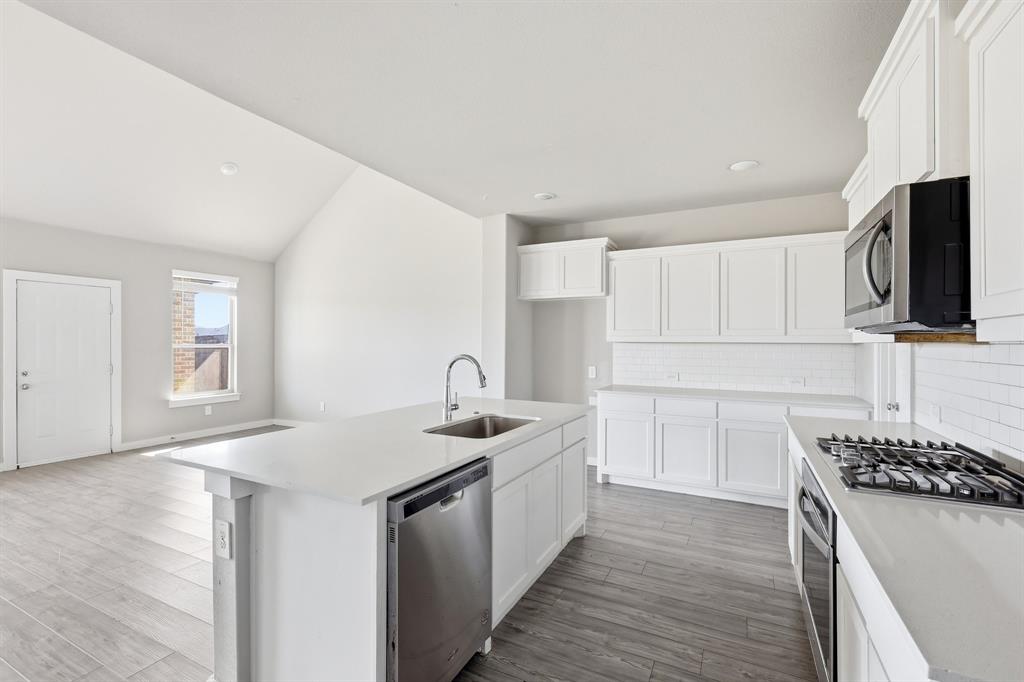 348 Braves Way Lavon, TX 75166 - Photo 5 of 26 a kitchen with a sink stove and microwave