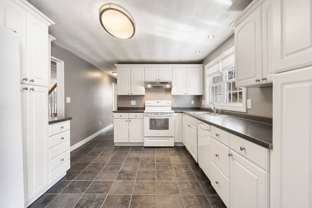 15 Ruthellen Road Chelmsford, MA 01824 - Photo 4 of 34 a large white kitchen with granite countertop a stove a sink dishwasher and a refrigerator