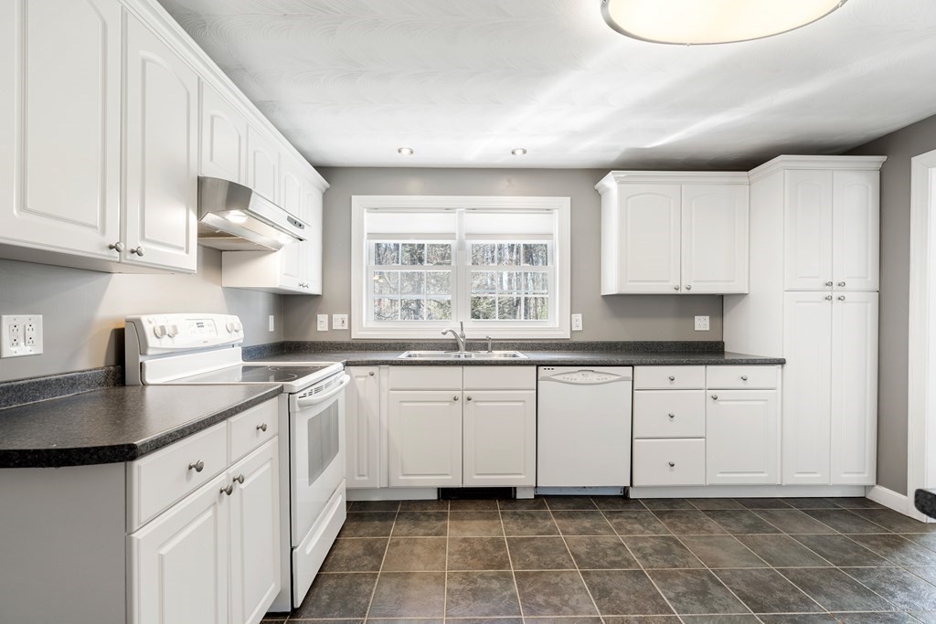 15 Ruthellen Road Chelmsford, MA 01824 - Photo 5 of 34 a kitchen with granite countertop white cabinets white appliances with a sink and dishwasher