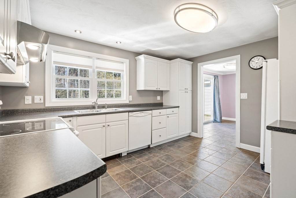 15 Ruthellen Road Chelmsford, MA 01824 - Photo 6 of 34 a kitchen with granite countertop a stove a sink and a refrigerator