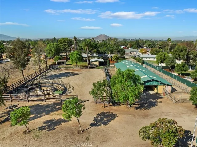 a view of house in front of a big yard with large trees