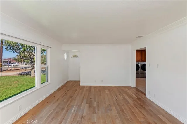 an empty room with windows and ceiling fan