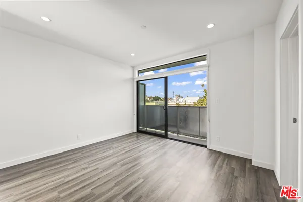 an empty room with wooden floor and door
