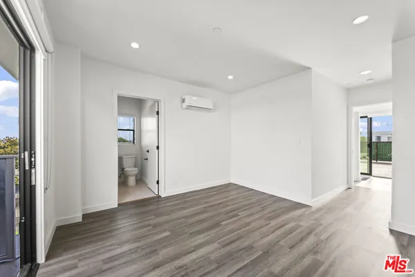 a view of an empty room with wooden floor and closet