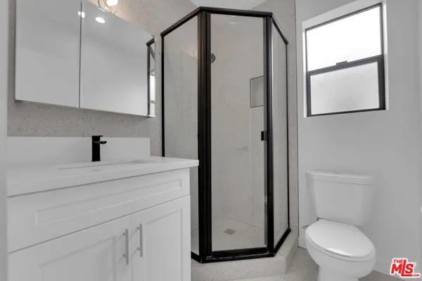 a bathroom with a toilet a sink and a mirror