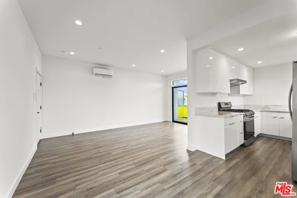 a kitchen with a sink wooden floor and stainless steel appliances