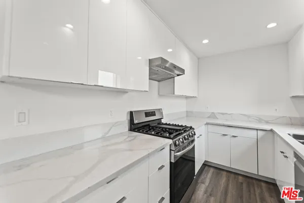 a kitchen with cabinets appliances a sink and a counter top space