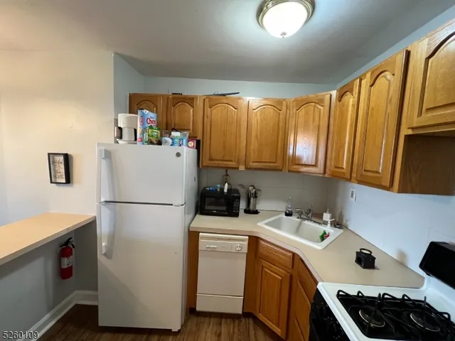 a kitchen with a refrigerator a stove a sink and cabinets