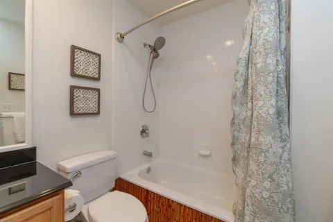 a white toilet sitting next to a bath tub shower