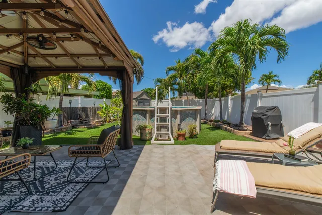 a view of a chair and table in backyard of the house