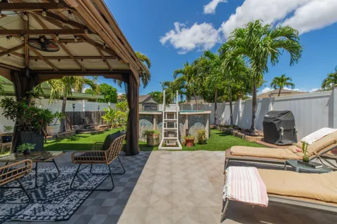 a view of a chair and table in backyard of the house