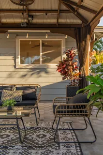 a roof deck with table and chairs and potted plants
