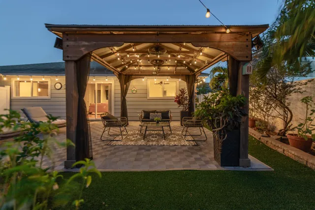 a view of a porch with a table and chairs under an umbrella